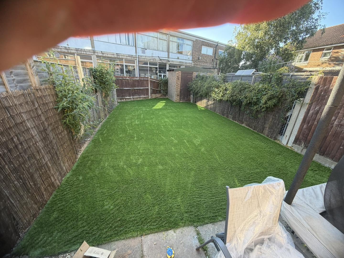 A long narrow garden finished with artificial grass from fence to fence