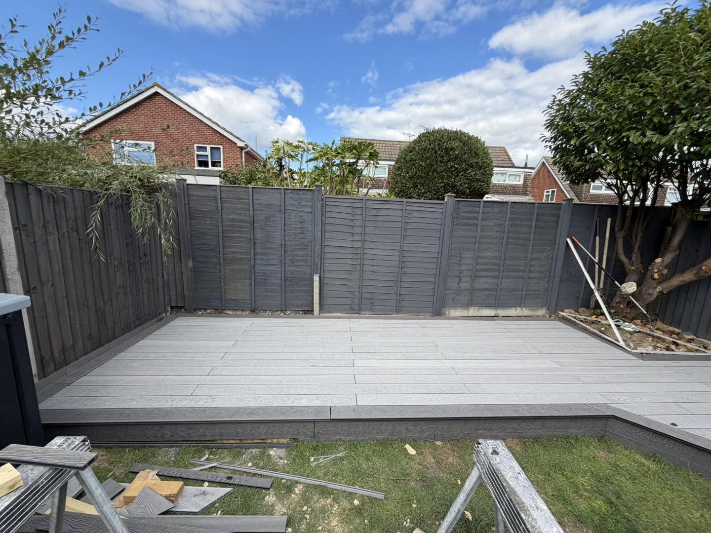Grey decking laid along a grey fence in a Felpham garden