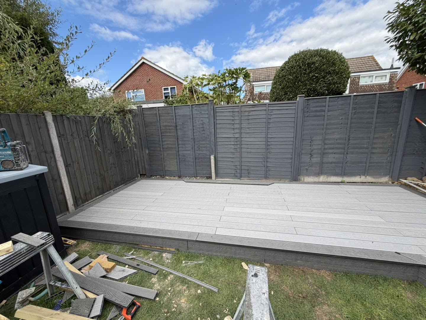 New grey decking along the back fence of a garden in Felpham