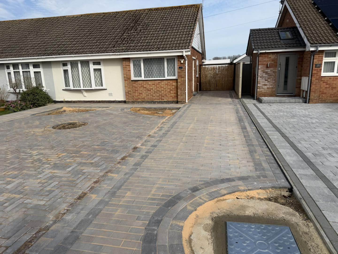The finished driveway in grey block paving with charcoal banding and a curved border