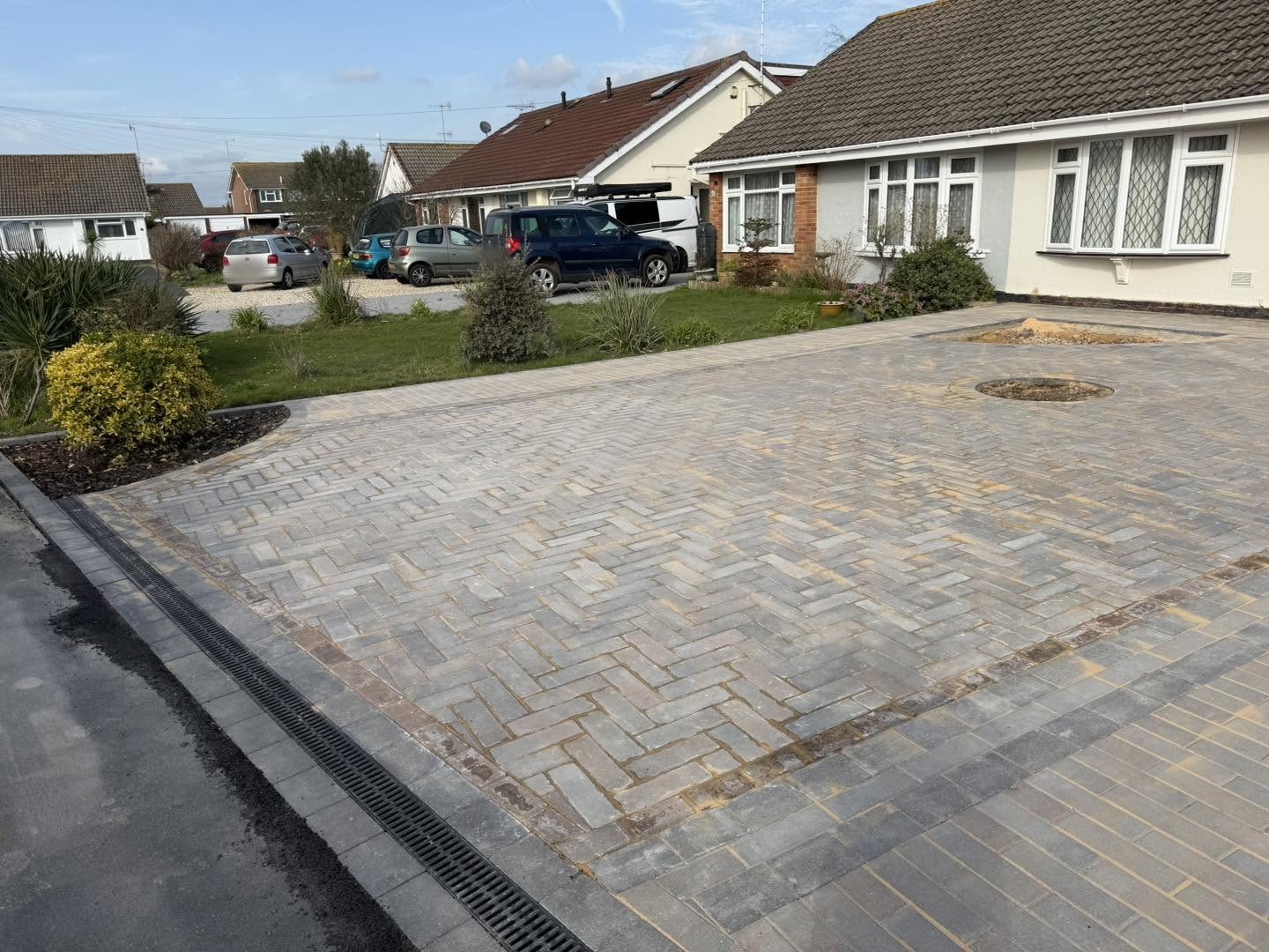 The finished herringbone driveway in front of the bungalow