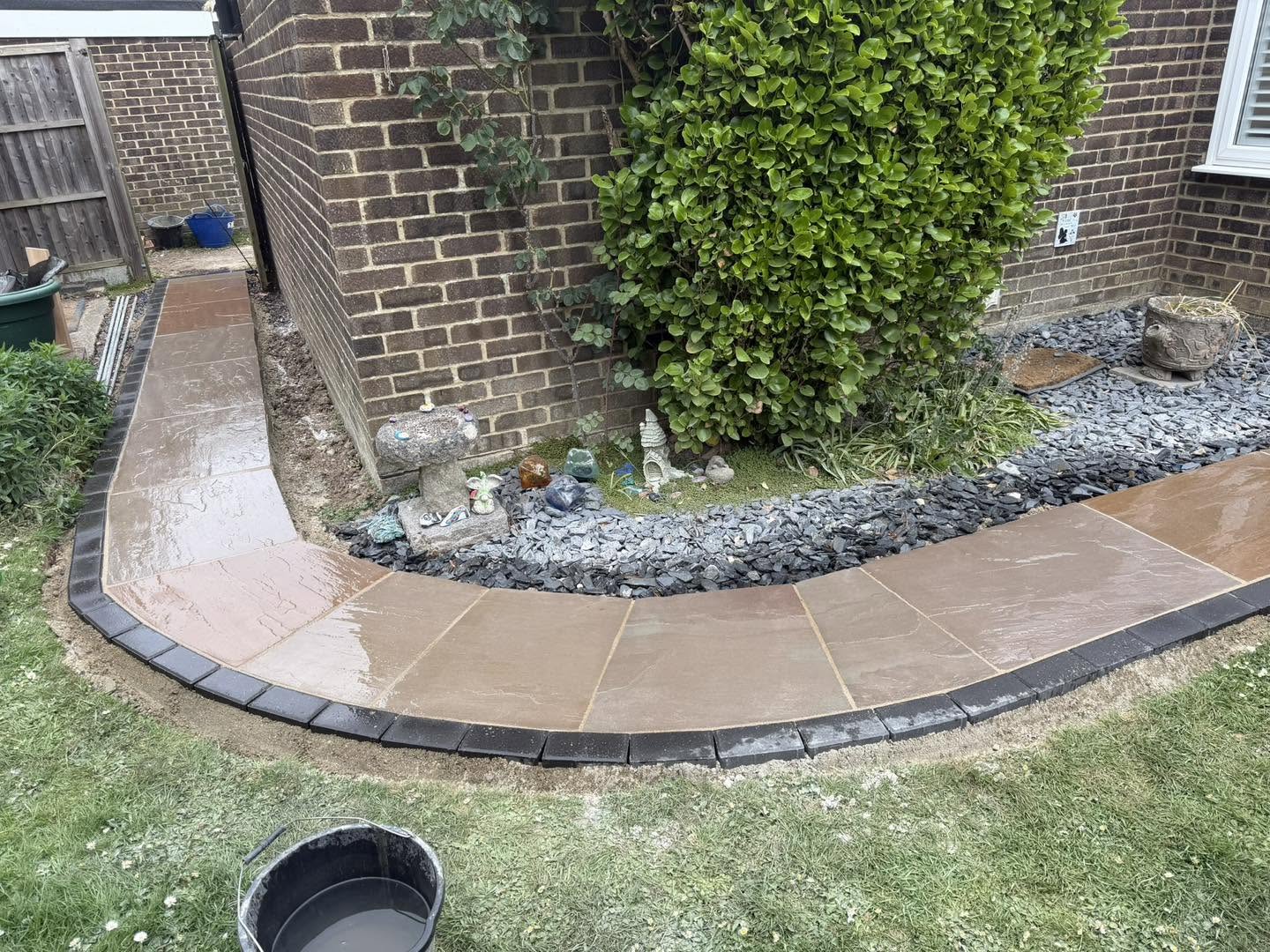 The curved path finished with a dark block edge and slate chippings